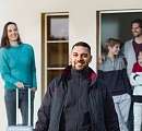 Un employé accueille une famille de quatre personnes devant le Sunstar Hotel – un voyage durable avec le Rail Pass Sunstar.