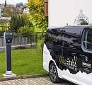 Borne de recharge électrique à côté du bus électrique de la Chäs Stuba au Sunstar Hotel Klosters – une mobilité durable au quotidien.
